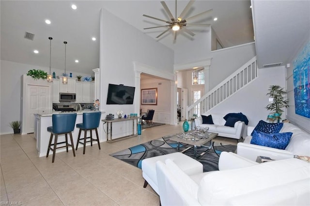 tiled living room with high vaulted ceiling and ceiling fan