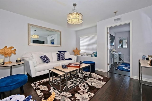 living room featuring dark hardwood / wood-style floors and an inviting chandelier