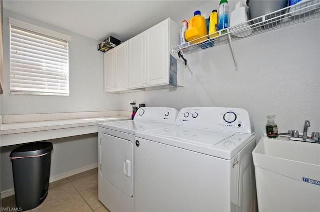 washroom with light tile floors, cabinets, sink, and washer and clothes dryer