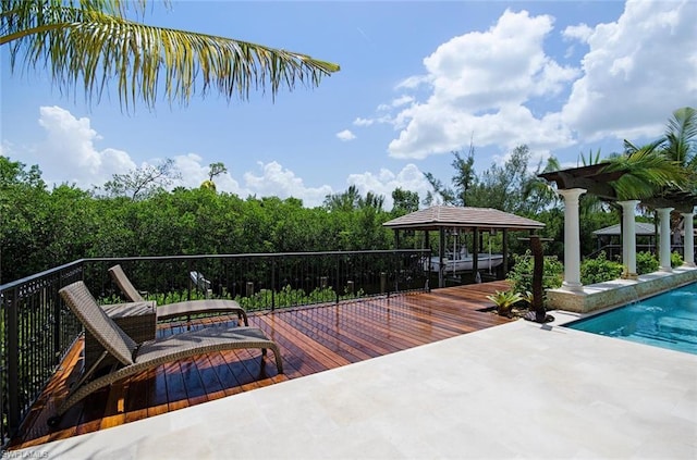 wooden terrace featuring a gazebo and a fenced in pool