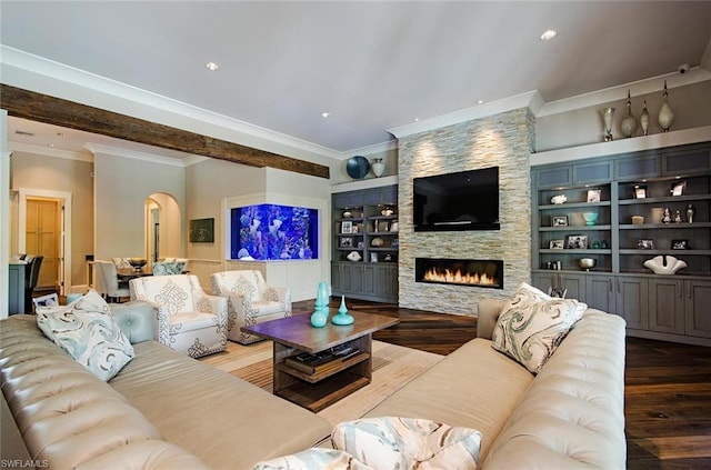 living room featuring built in features, a stone fireplace, wood-type flooring, and crown molding