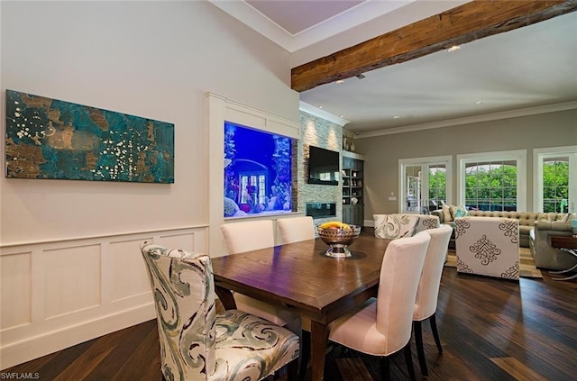 dining area with french doors, beam ceiling, a stone fireplace, and dark wood-type flooring