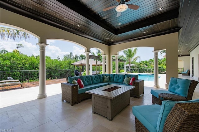 view of patio / terrace featuring a fenced in pool, a gazebo, ceiling fan, and an outdoor living space with a fire pit