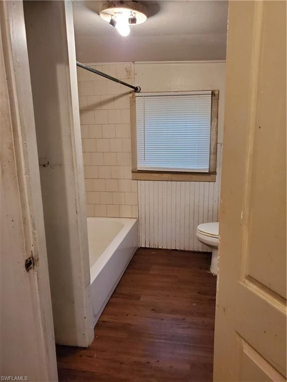 bathroom featuring toilet, shower / washtub combination, and wood-type flooring