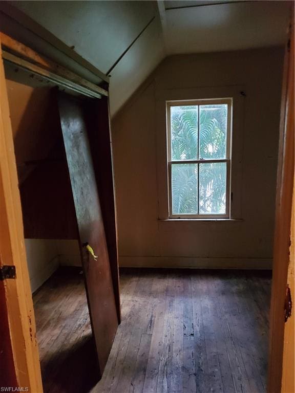 bonus room with dark wood-type flooring and lofted ceiling