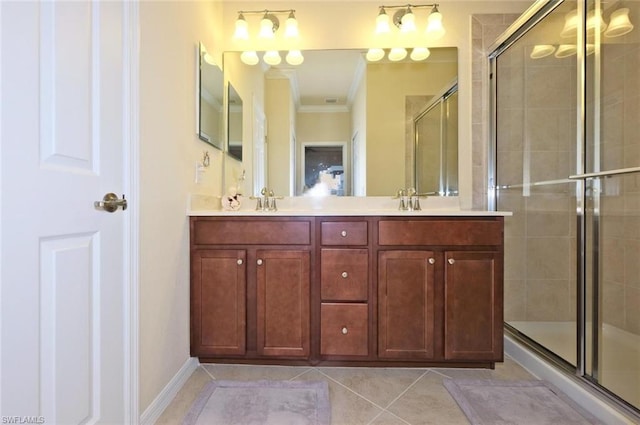 bathroom with dual vanity, tile floors, a shower with shower door, and crown molding