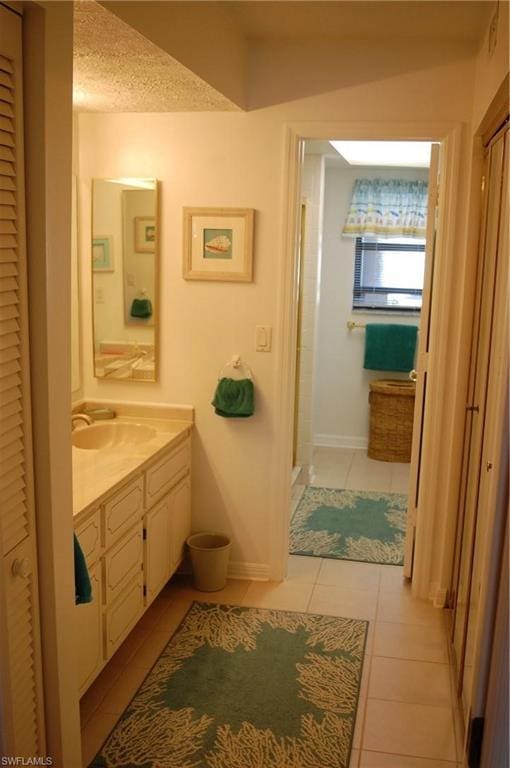 bathroom featuring a textured ceiling, tile floors, and vanity with extensive cabinet space