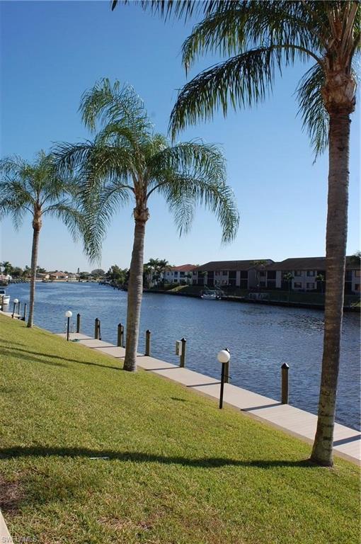 dock area with a water view and a yard