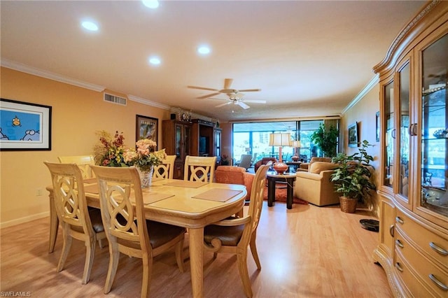 dining space featuring light hardwood / wood-style floors, ornamental molding, and ceiling fan