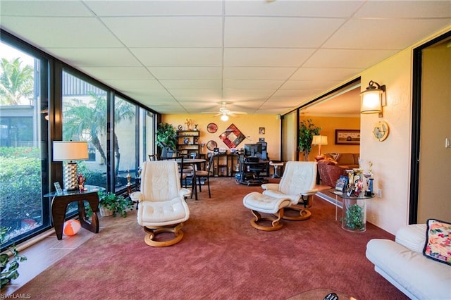 living room featuring a paneled ceiling, a wall of windows, and ceiling fan