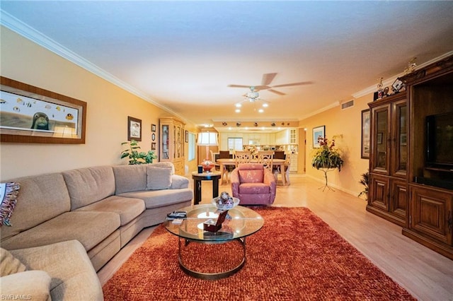 living room featuring light hardwood / wood-style floors, ceiling fan, and ornamental molding