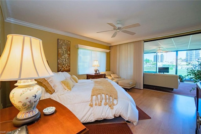 bedroom with crown molding, wood-type flooring, and ceiling fan