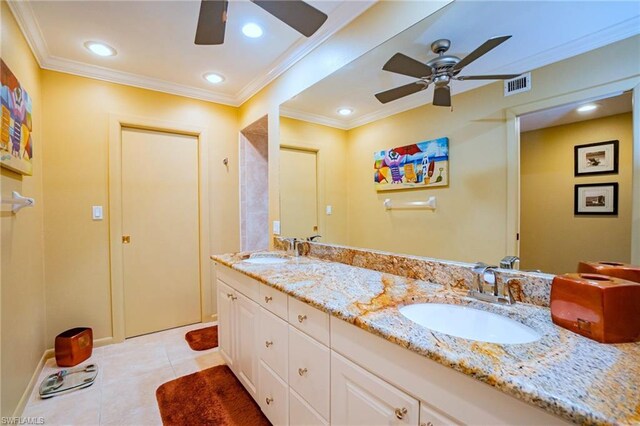 bathroom with tile floors, vanity with extensive cabinet space, double sink, and ceiling fan