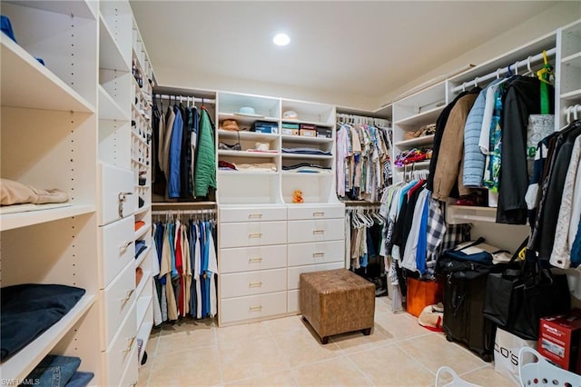 walk in closet with light tile floors