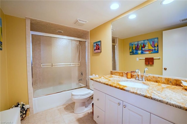 full bathroom featuring shower / bath combination with glass door, tile flooring, vanity with extensive cabinet space, and toilet