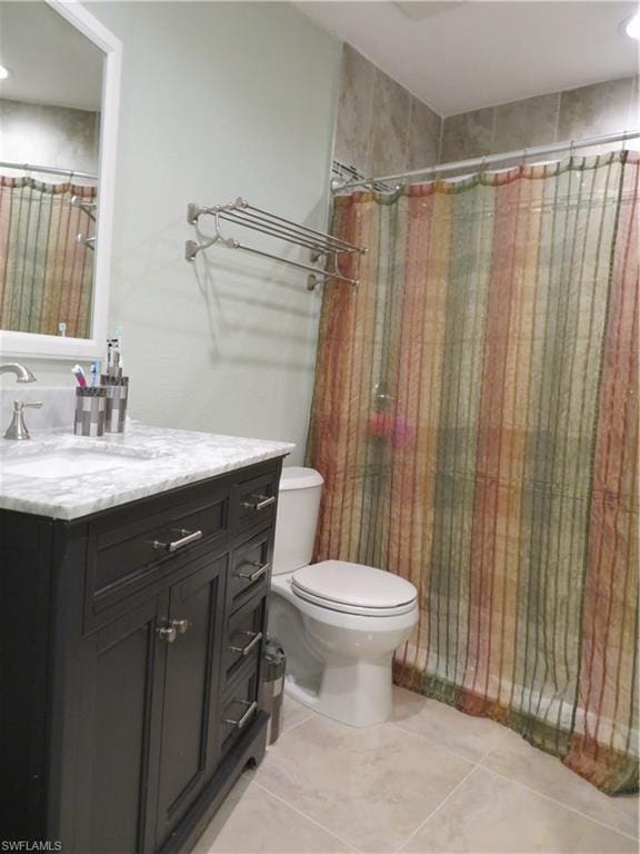 bathroom featuring vanity, tile floors, and toilet