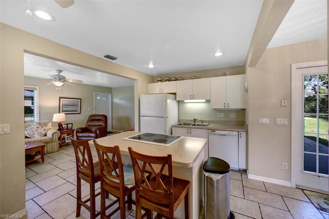 kitchen with white appliances, ceiling fan, light tile floors, sink, and white cabinets