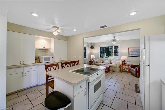 kitchen with white cabinets, light tile floors, ceiling fan, and white appliances