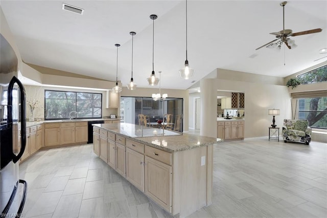 kitchen featuring pendant lighting, a kitchen island, light tile flooring, vaulted ceiling, and light stone countertops