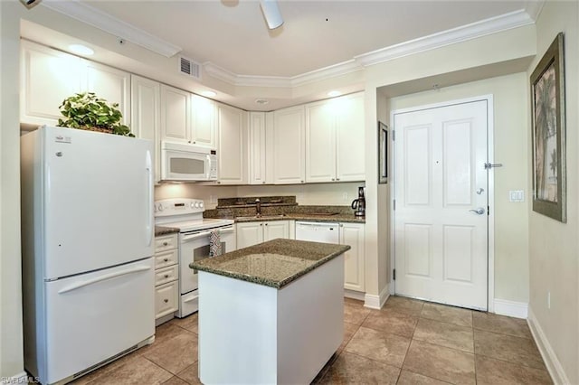 kitchen featuring white appliances, light tile floors, a kitchen island, dark stone countertops, and white cabinetry