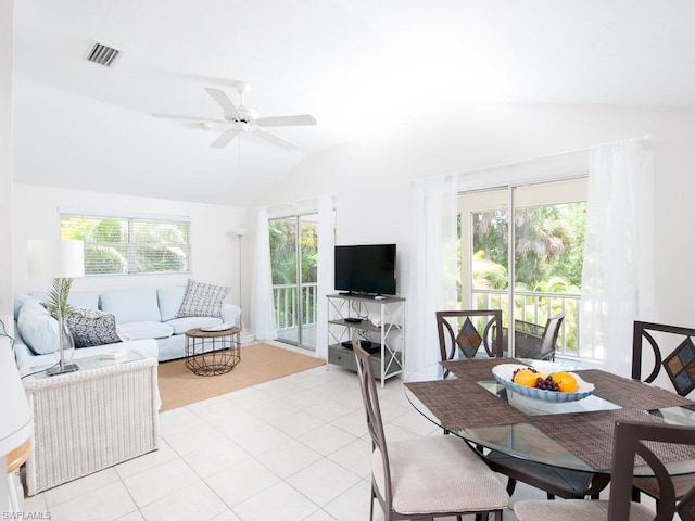 dining room featuring plenty of natural light, light tile floors, vaulted ceiling, and ceiling fan