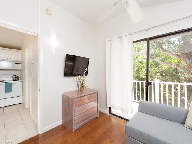 tiled living room with lofted ceiling and ceiling fan