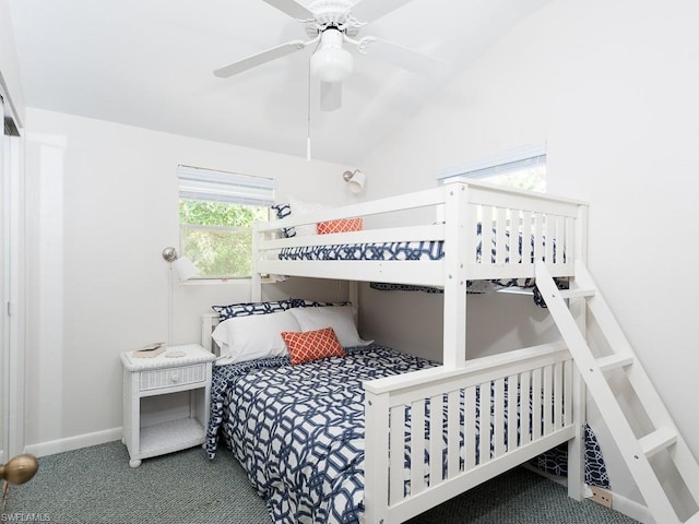 bedroom with dark carpet, ceiling fan, and vaulted ceiling