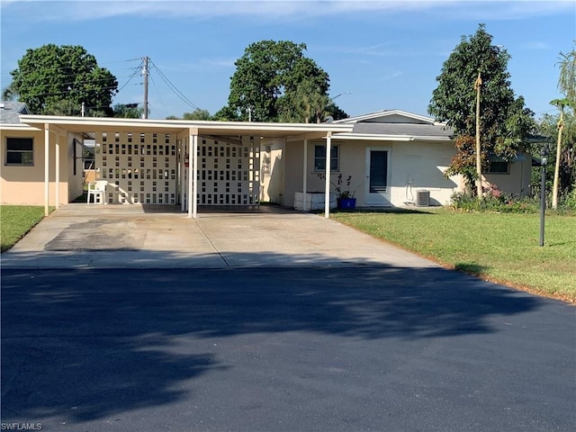 ranch-style house featuring a carport, a front yard, and central AC unit