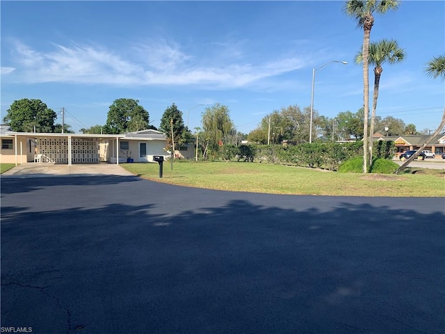 view of front of property with a front yard and a carport