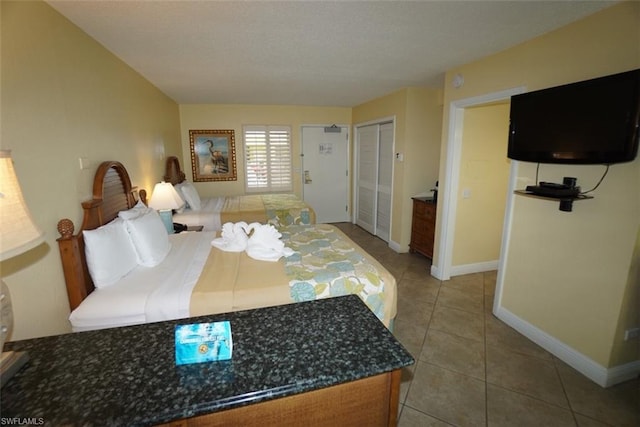 bedroom with a closet and light tile floors