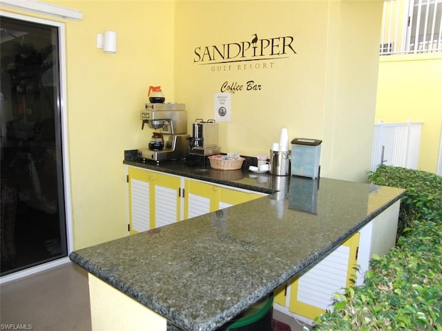 kitchen with kitchen peninsula and dark stone counters