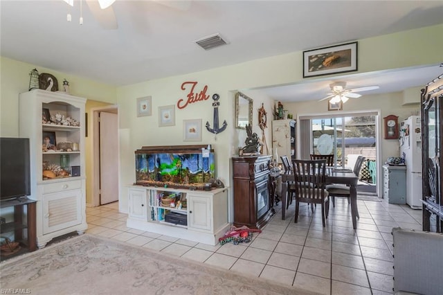 kitchen with white cabinets, light tile floors, ceiling fan, and white refrigerator