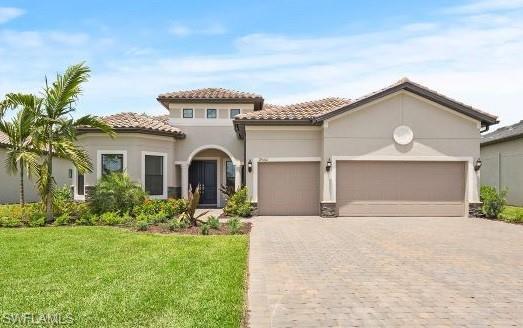 mediterranean / spanish-style home featuring a front yard and a garage