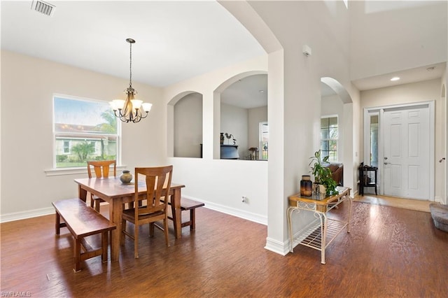 dining area featuring an inviting chandelier and dark hardwood / wood-style flooring