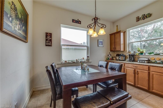 dining space featuring a notable chandelier and light tile floors