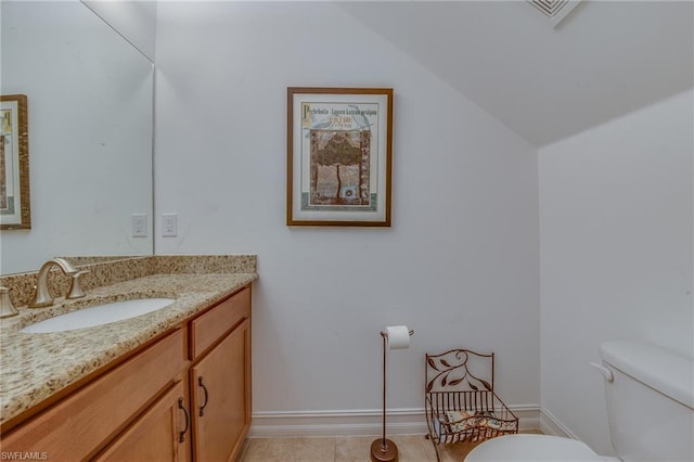 bathroom featuring tile floors, vanity with extensive cabinet space, and toilet