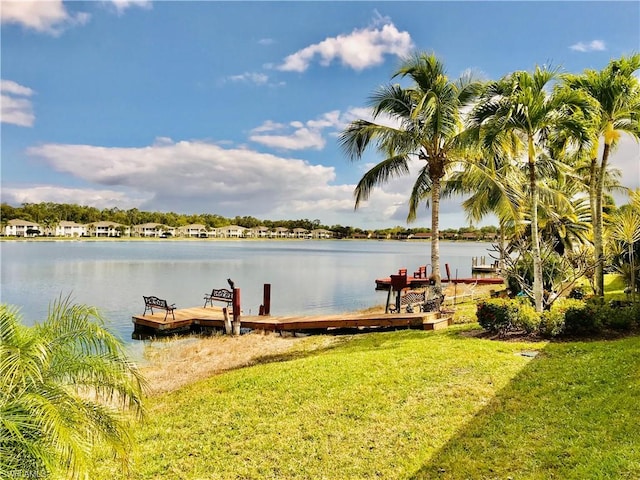 view of dock featuring a water view and a yard