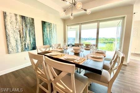 dining area with dark hardwood / wood-style floors and a notable chandelier