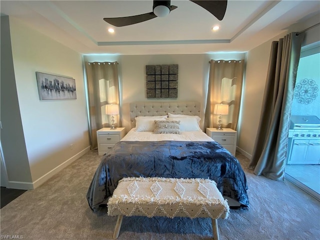 bedroom featuring carpet floors, a raised ceiling, and ceiling fan