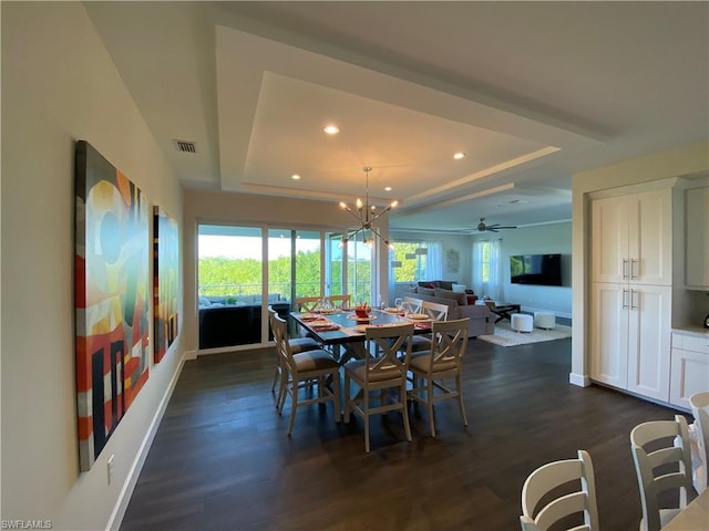 dining space featuring a raised ceiling, dark hardwood / wood-style floors, and ceiling fan with notable chandelier