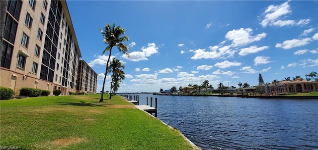 view of dock featuring a lawn and a water view