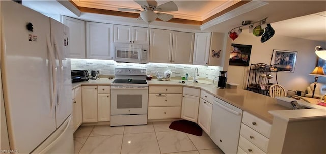 kitchen featuring a tray ceiling, white appliances, and white cabinetry