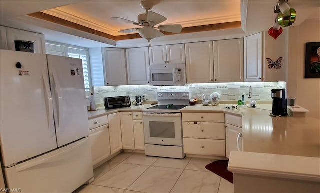 kitchen with white cabinetry, ceiling fan, white appliances, light tile floors, and a raised ceiling