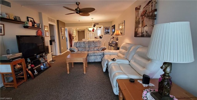 living room featuring ceiling fan with notable chandelier and dark colored carpet