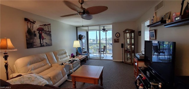 living room with plenty of natural light, ceiling fan, and dark carpet