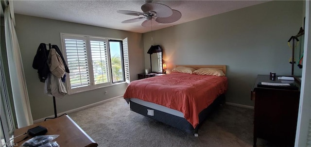 carpeted bedroom featuring ceiling fan and a textured ceiling