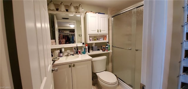 bathroom featuring toilet, walk in shower, and vanity