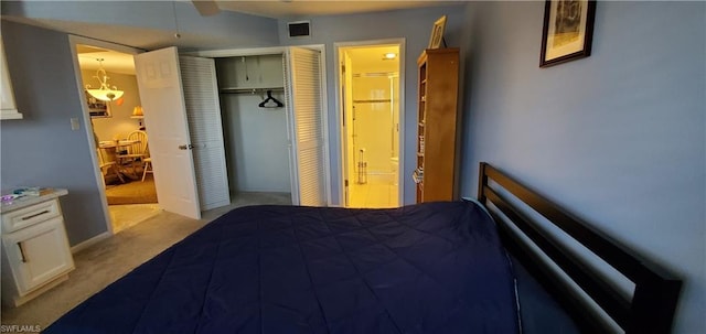 carpeted bedroom with a closet, ceiling fan, and ensuite bathroom