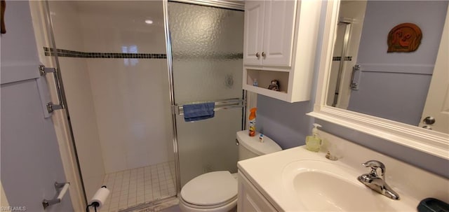 bathroom featuring a shower with shower door, toilet, and large vanity