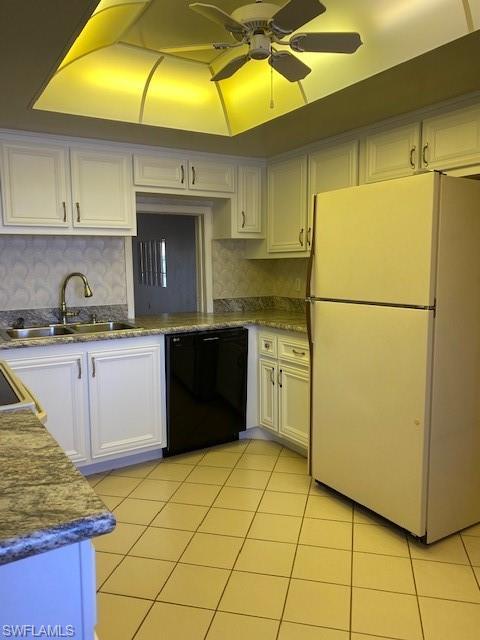 kitchen with white refrigerator, black dishwasher, ceiling fan, tasteful backsplash, and white cabinetry